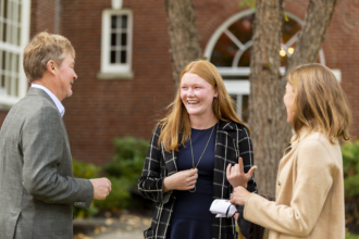 A young woman talks to an older man and woman