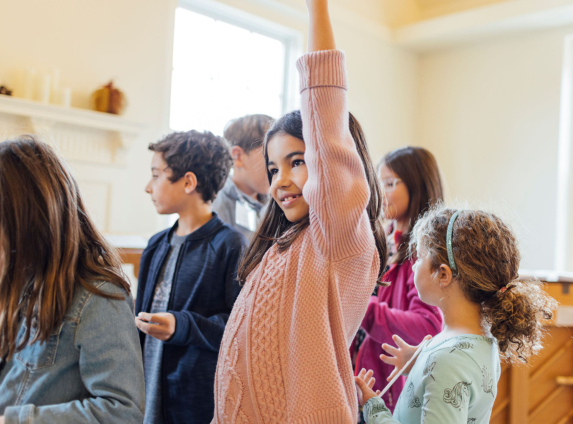 Child raises her hand in classroom