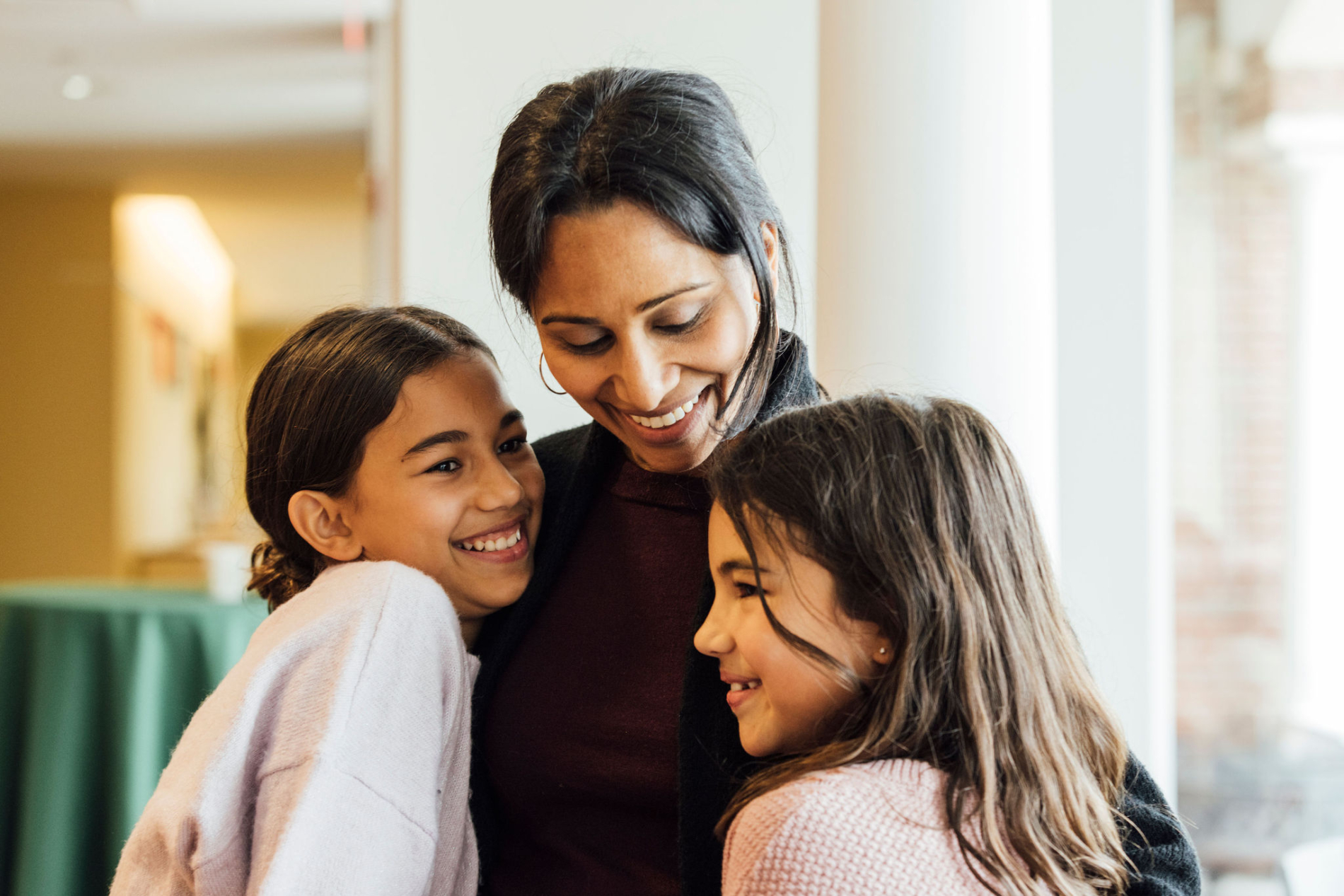 Mom hugs her daughters